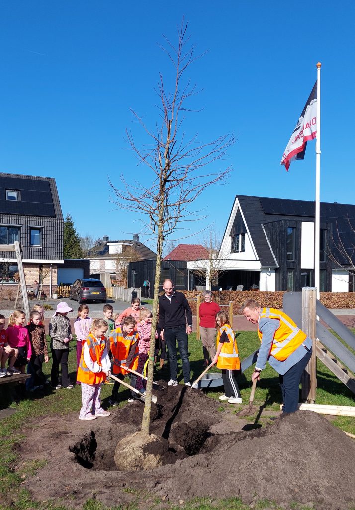 Kinderen die samen met wethouder een toekomstboom planten